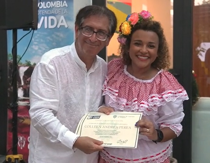 El Embajador Manuel Solano entrega los certificados de participación a los integrantes del grupo de danzas colombianas.